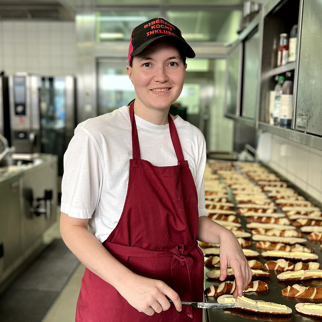 Küchenhilfe lächelt und bereitet Brotzeit vor